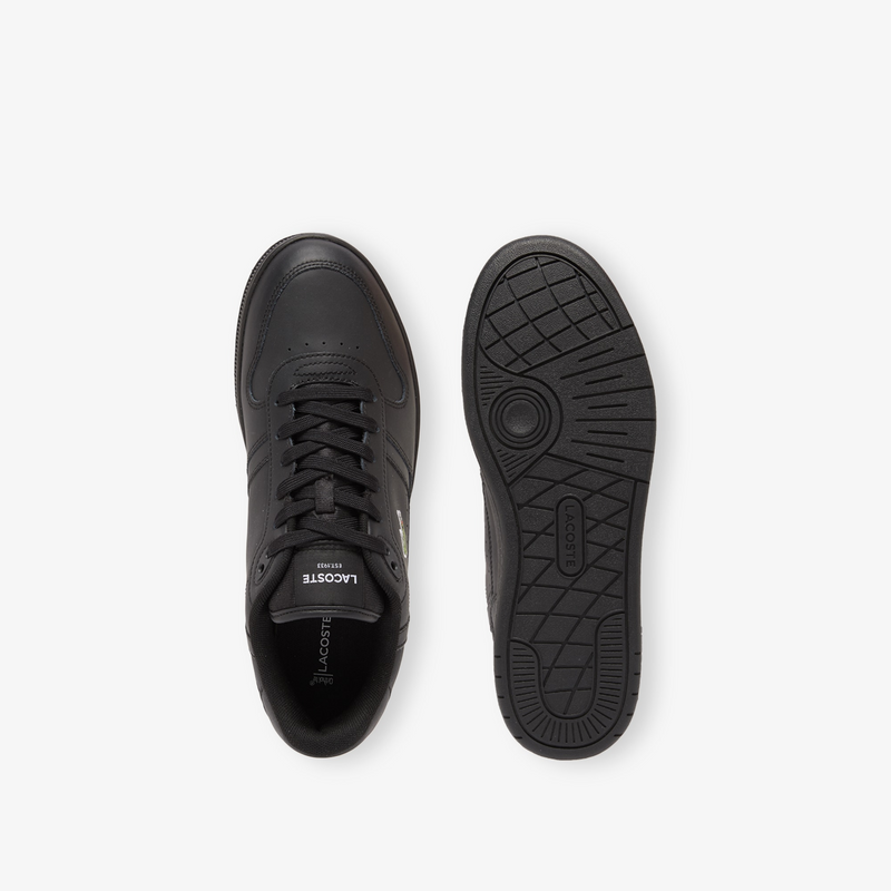 Lacoste T-Clip Set 224 2 SMA sneakers in black leather, top view showing lace-up design and sole view with textured rubber tread.