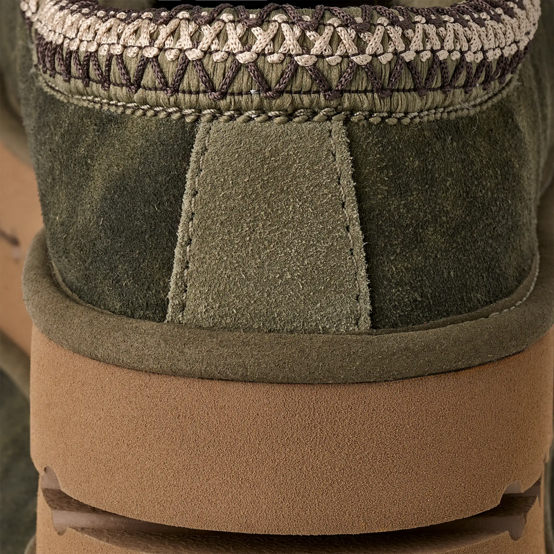 UGG Tasman Baxter shoes in olive green suede with intricate braided detailing and a sturdy brown sole, back view.