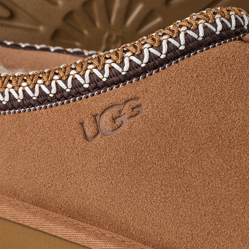 UGG Tasman II Slipper in chestnut brown suede with stitched detailing and embossed logo, close-up of side view.