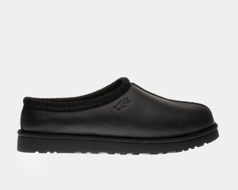UGG Tasman Leather Slipper in black with embossed logo and woven collar detail, side view.
