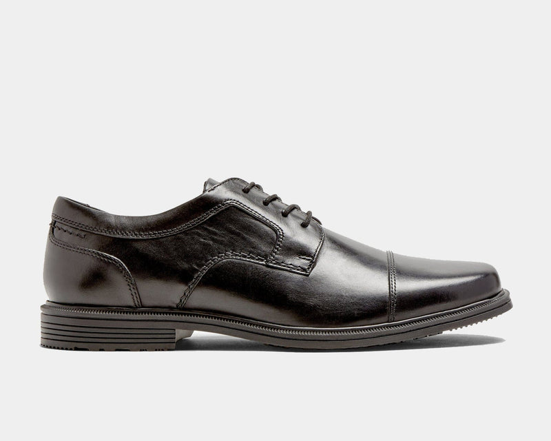 Rockport Taylor Cap Toe dress shoes in black leather with stitched detailing and a cap toe design, side view.