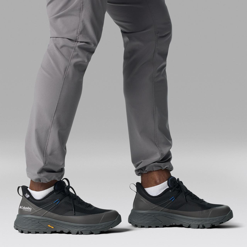 Columbia Tellurix Titanium OutDry shoes in black and gray with waterproof OutDry technology and Vibram outsole, side view worn by person walking.