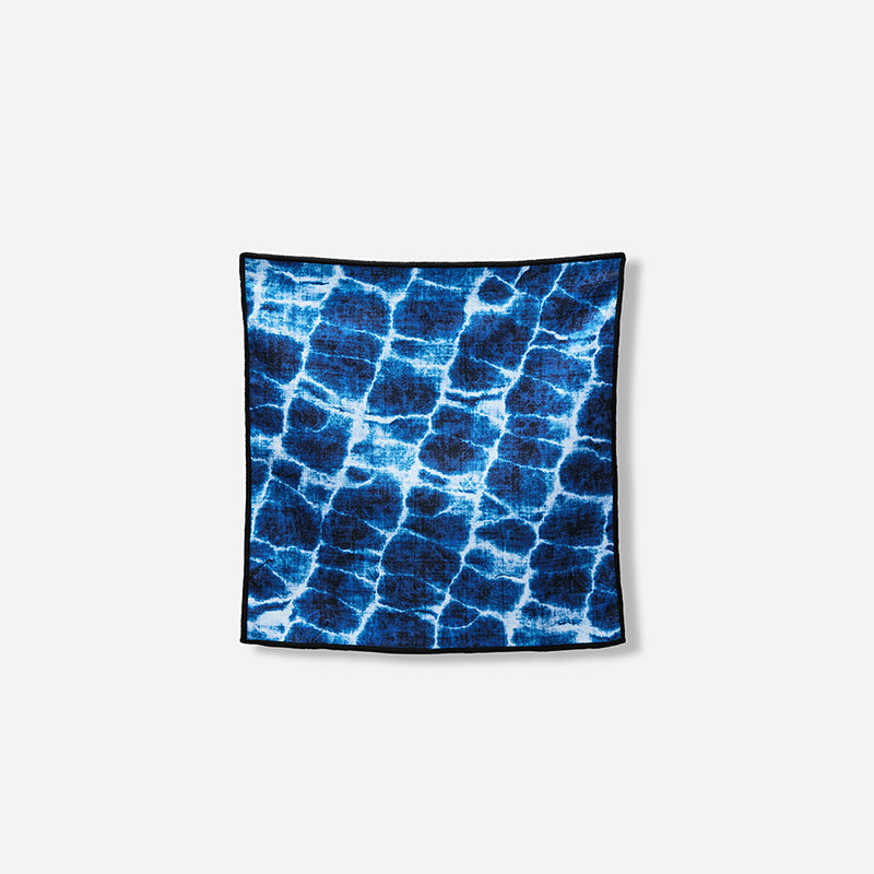 Nomadix Tiny Towel 3-Pack towel in blue with water ripple pattern and black edging, front view.