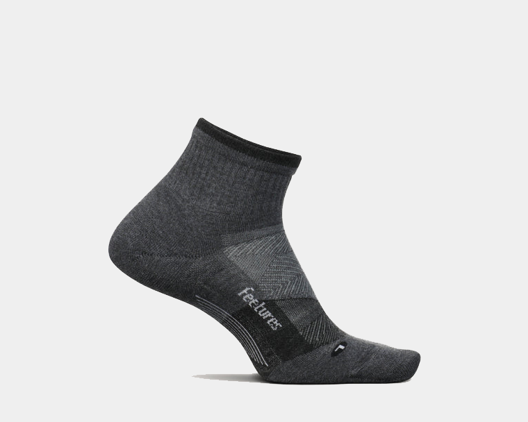 Feetures Trail Max Cushion Quarter Sock in dark gray with reinforced arch support and cushioned design, side view.