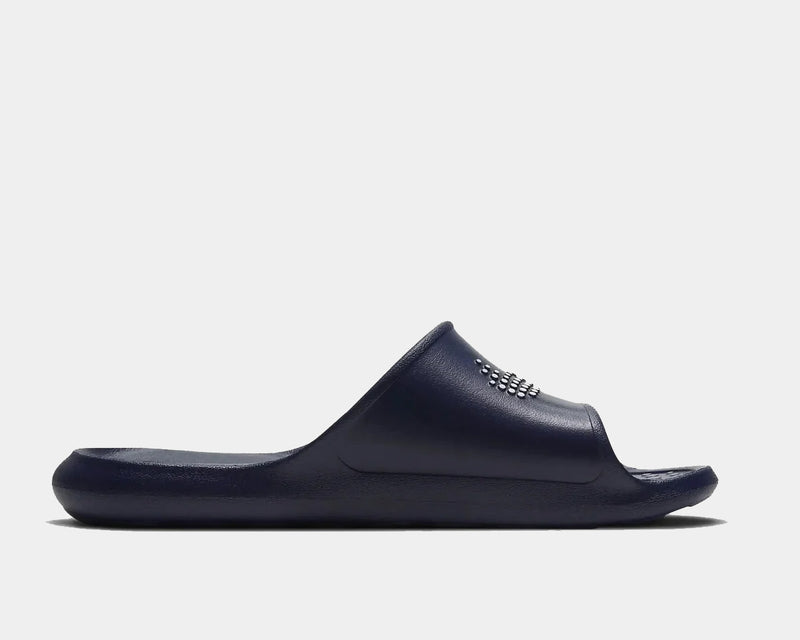 Nike Victori One Shower slide sandals in navy blue, featuring a textured footbed and synthetic strap, side view.