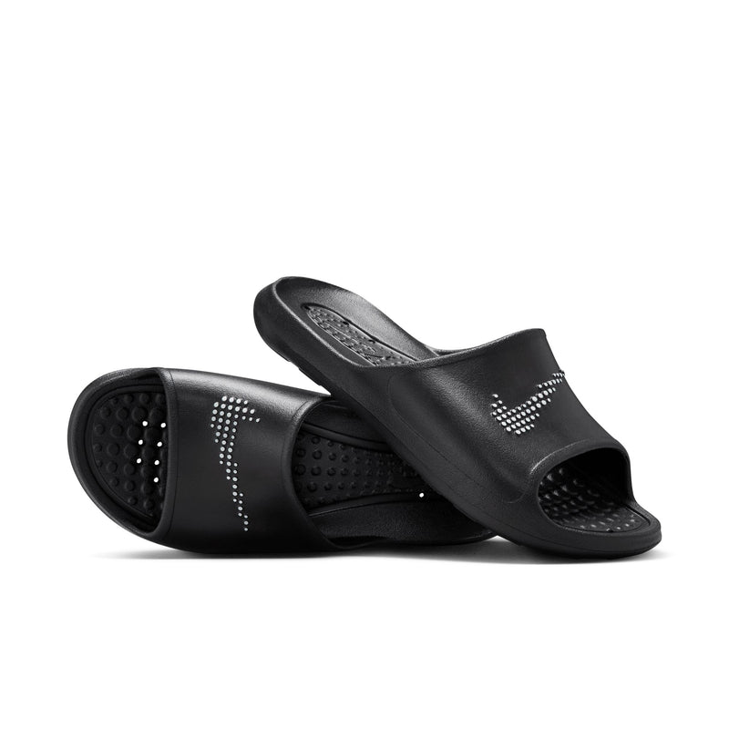 Nike Victori One Shower sandals in black with textured footbed and perforated design for water drainage, angled view.