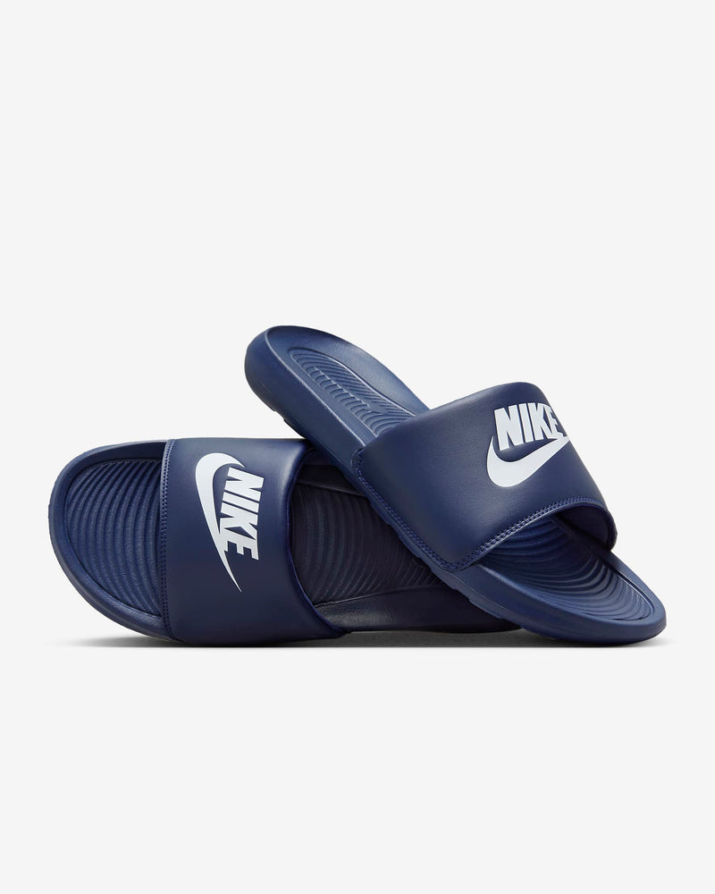 Navy slide sandal with a brand logo on a light gray background