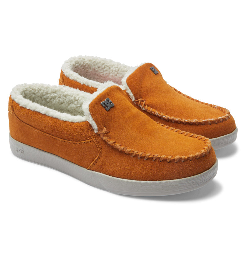 DC Footwear Villain 2 SE slip-on shoes in orange suede with moc-toe stitching, white fleece lining, and white rubber outsole, angled side view.