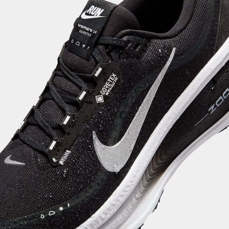 Nike Vomero 18 GORE-TEX running shoes in black with water-resistant GORE-TEX material, silver Swoosh logo, and cushioned sole, close-up view.
